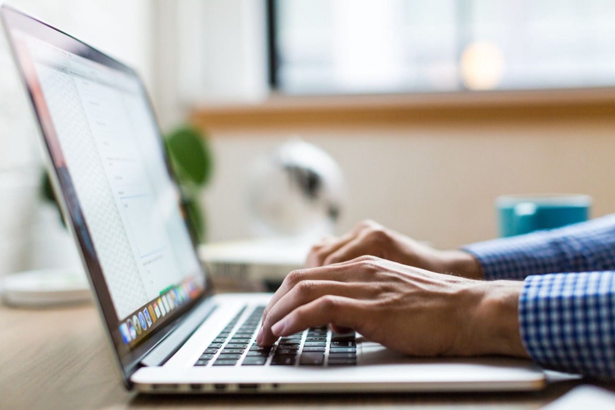 Una persona che analizza le statistiche di apertura delle email su un laptop.