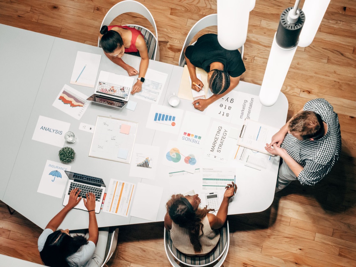 team di marketing digitali in un ufficio con monitor e laptop in discussione di strategia SEM