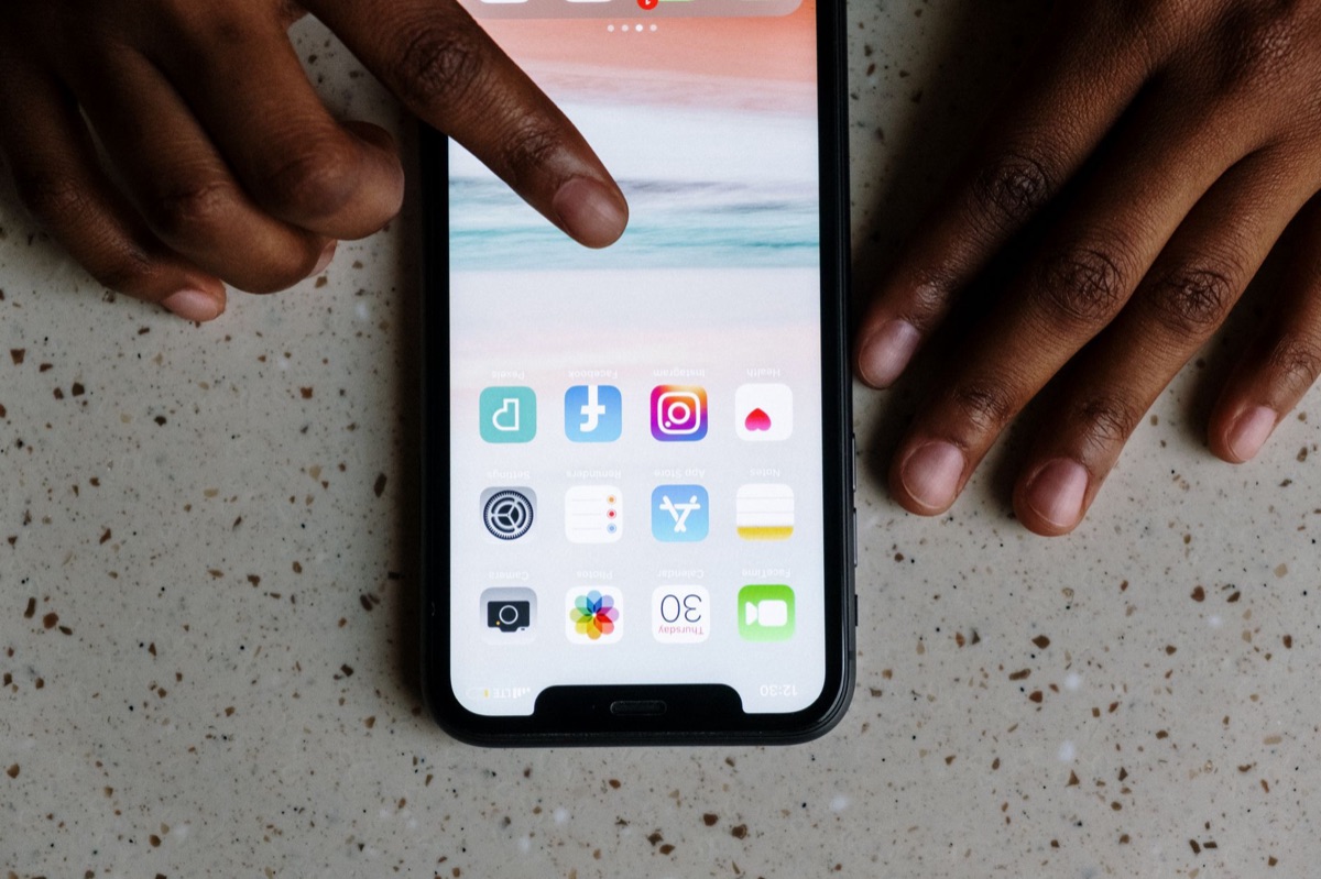 スマートフォンの画面をタップする指のアップ