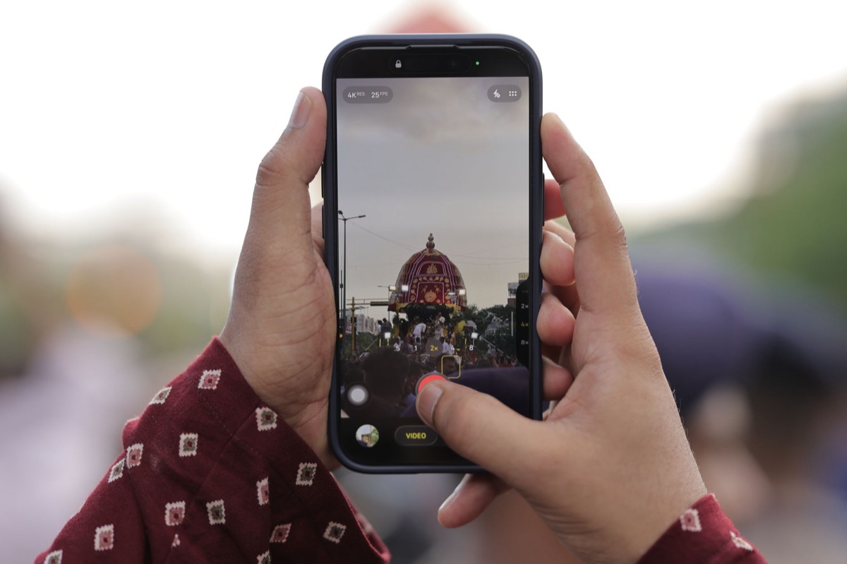 Mão segurando smartphone com foco em conteúdo vertical