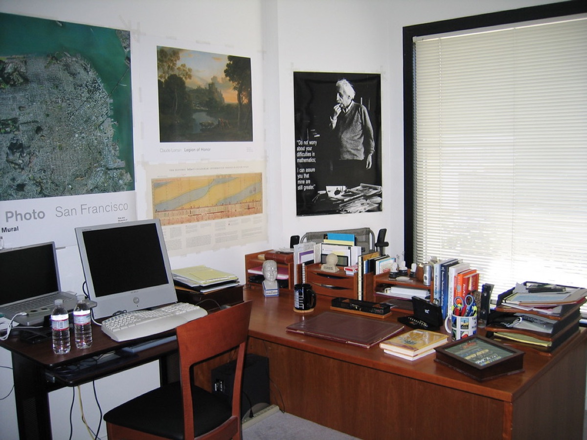 Home office with rain on the window, laptop showing data analysis, 16:9, documentary style